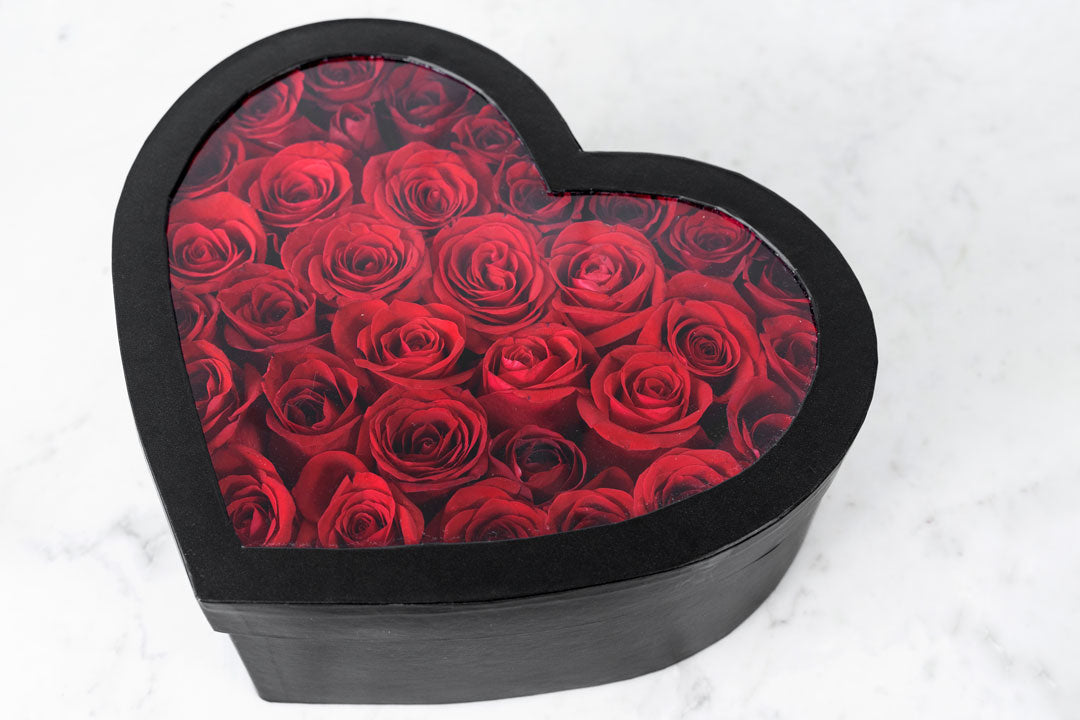 Flores rojas en caja de corazón