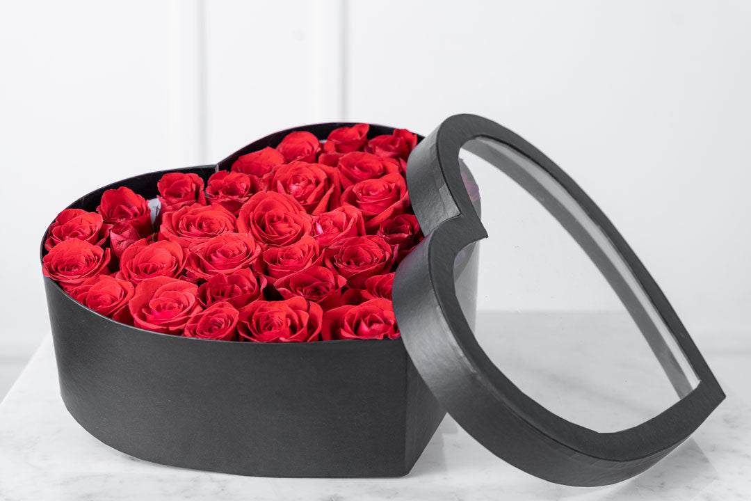 Flores rojas en caja de corazón