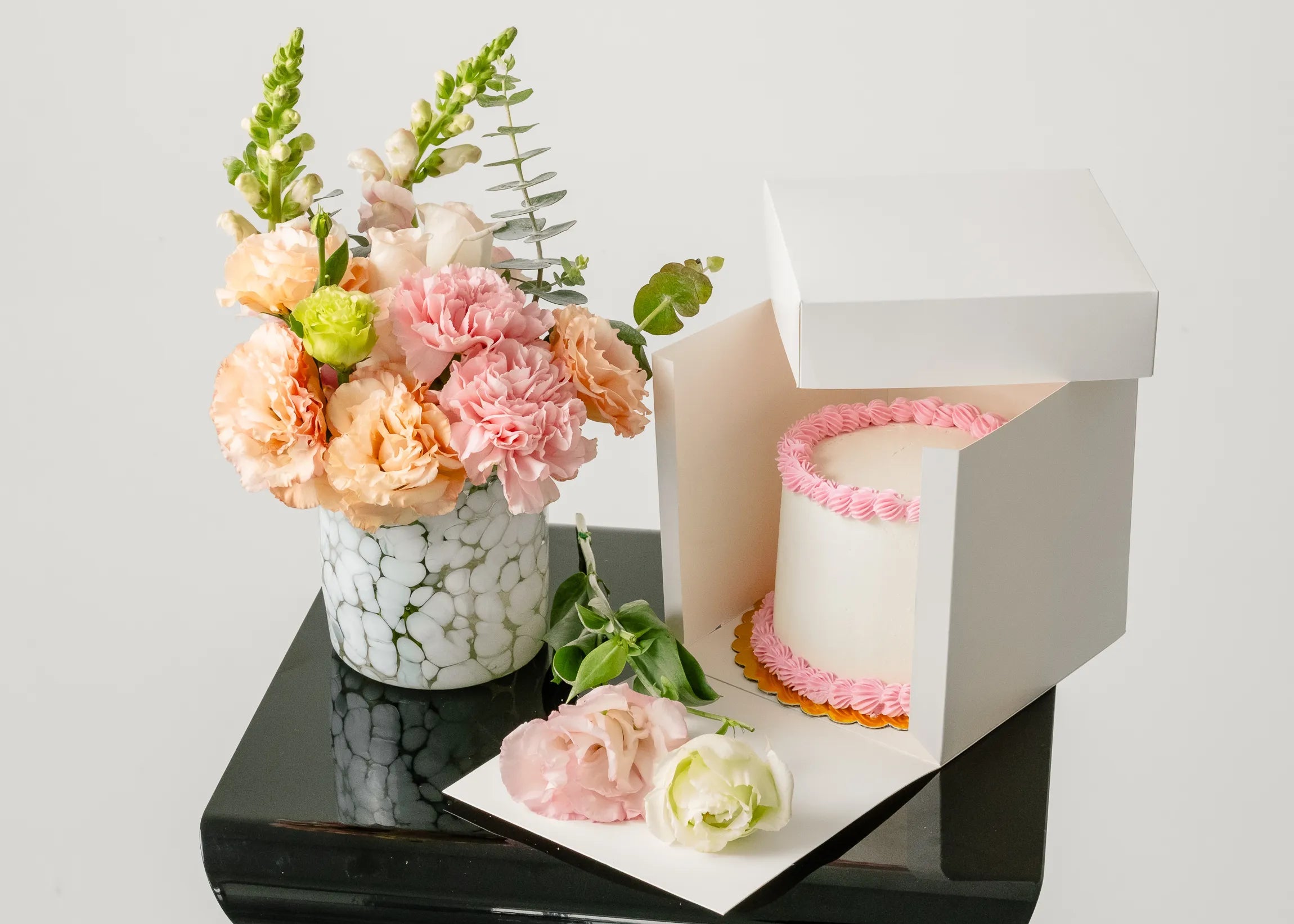 Pastel rosa con florero de cristal y flores