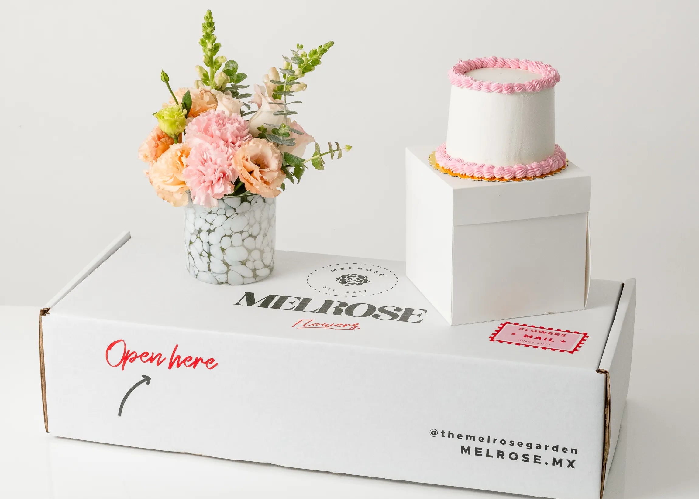 Pastel rosa con florero de cristal y flores