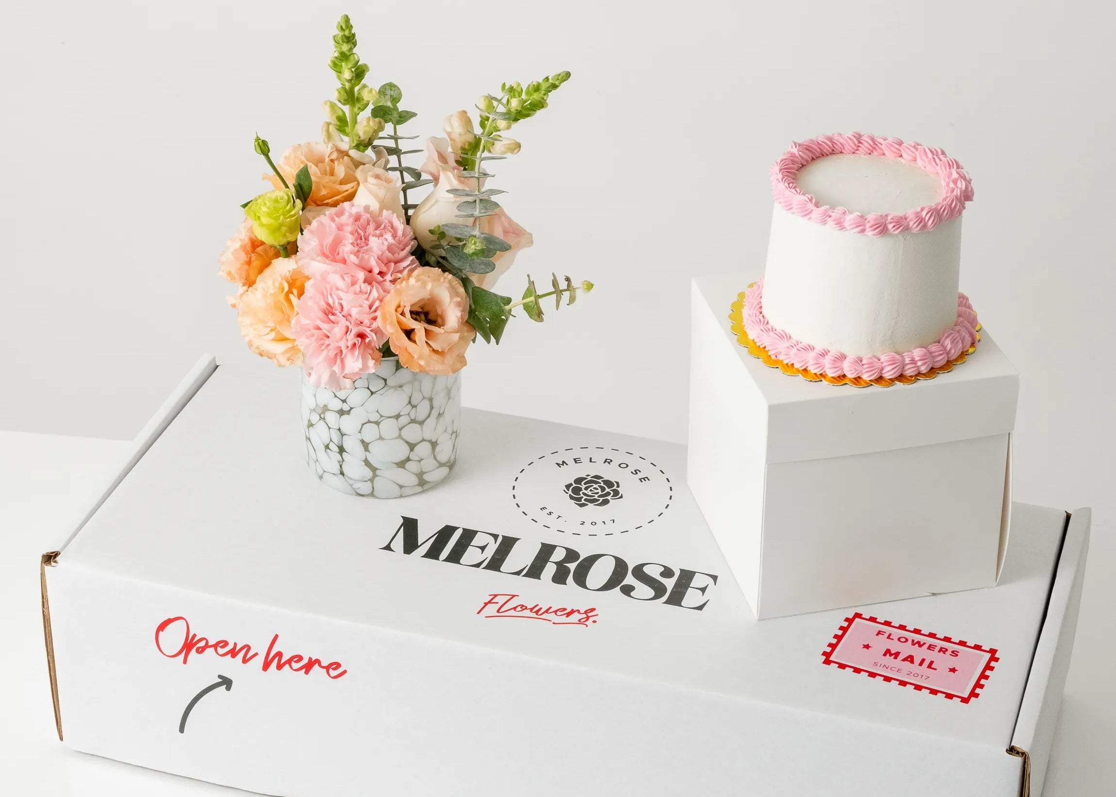 Pastel rosa con florero de cristal y flores